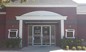 The image shows a building entrance with a brick facade, a white pillar, and a sign that reads Santa Rosa Medical Center.